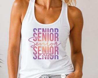 May include: White tank top with the word "SENIOR" in a gradient of purple, pink, and orange. The text "2026" is below the word "SENIOR". The tank top is a racerback style.