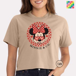 a woman wearing a tan minnie mouse shirt