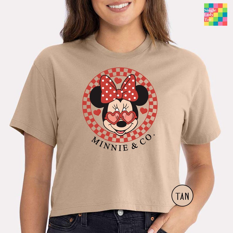 a woman wearing a tan minnie mouse shirt