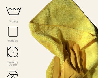 Op de afbeelding: Een gele microvezel schoonmaakdoek gevouwen in tweeën. De doek is zacht en absorberend, waardoor hij ideaal is voor het reinigen van oppervlakken.