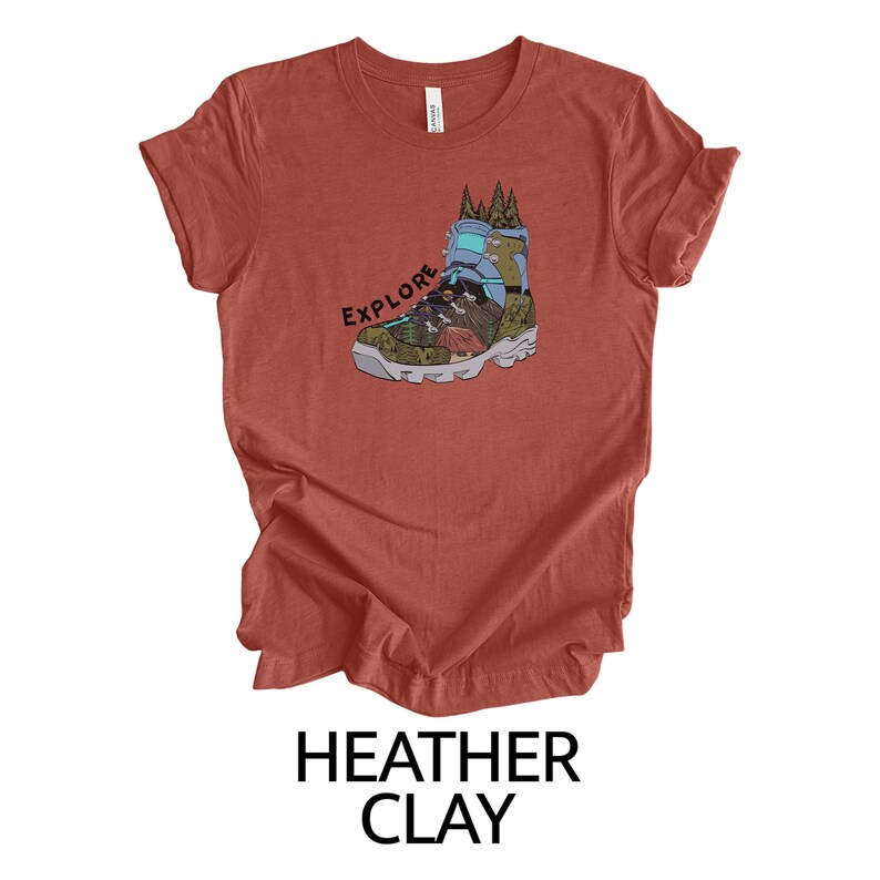 May include: A heather clay t-shirt with a graphic of a hiking boot with the word "EXPLORE" printed on it.