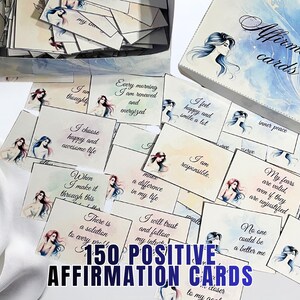 May include: A set of 150 positive affirmation cards with watercolor illustrations and inspirational quotes. The cards are in a box labeled "Affirmation cards". The text "150 Positive Affirmation Cards" is displayed prominently.