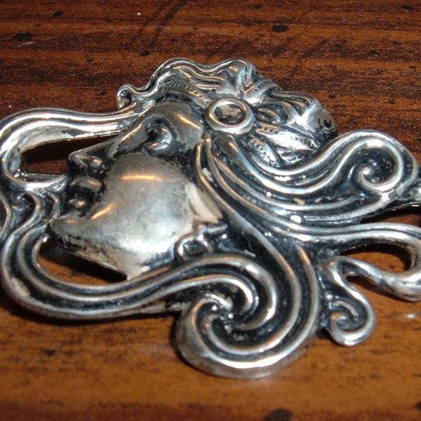 Vintage Art Nouveau brooch featuring a silver-tone antiqued finish, unsigned, measuring 2 inches.