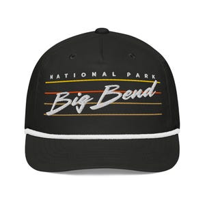 May include: Black cap with white rope detail and curved brim. The cap features the text "NATIONAL PARK" above "Big Bend" in a stylized font, with orange and brown horizontal lines. A classic accessory.