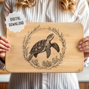 May include: A wooden chopping board with a laser-engraved design of a sea turtle surrounded by a wreath of seaweed.