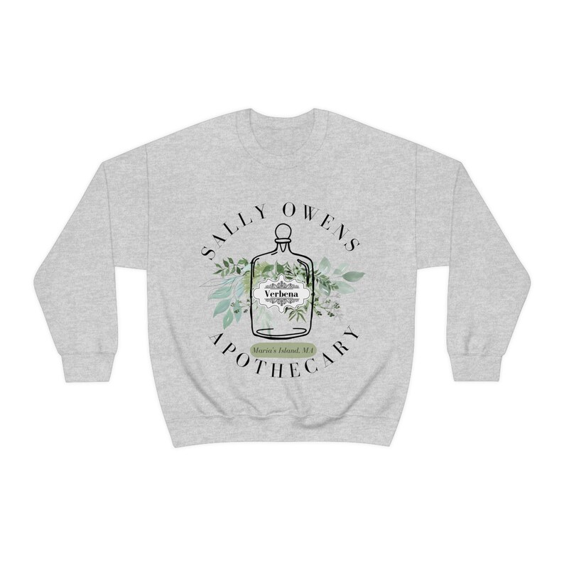 Może przedstawiać: Szara bluza z białym nadrukiem przedstawiającym butelkę z etykietą z napisem "Verbena" oraz tekstem "Sally Owens Apothecary, Morris Island, MA".