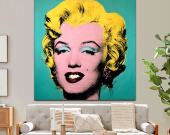 May include: A square wall art print featuring a stylized portrait of a person with bright yellow hair, light blue eyeshadow, and dark red lips against a solid teal background. The face is rendered in shades of pink with high contrast shadows.