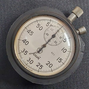 May include: A black and silver stopwatch with a white face and black hands. The face has markings for seconds, with numbers from 5 to 60. The stopwatch also has a smaller dial for 0.2 seconds. The text "СДЕЛАНО В СССР" is printed on the face, which translates to "Made in the USSR".