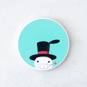 Puede incluir: Un posavasos redondo y blanco con un mu&ntilde;eco de nieve de dibujos animados con sombrero de copa negro, banda roja y pipa. El mu&ntilde;eco de nieve tiene una amplia sonrisa y est&aacute; sobre un fondo azul claro.