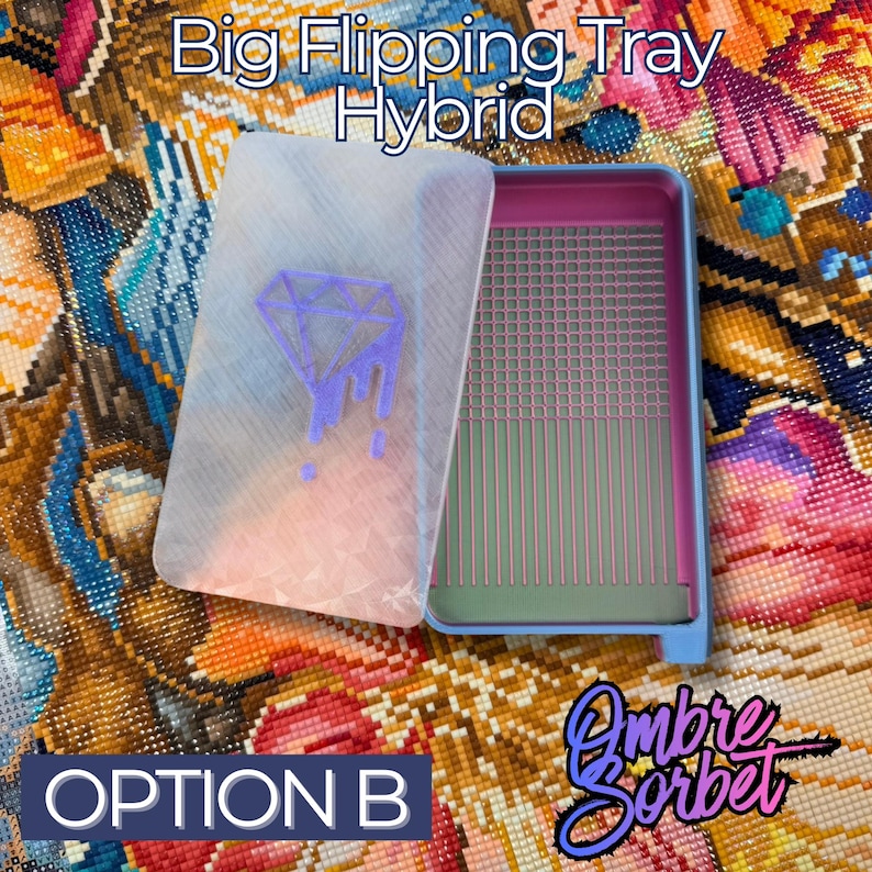 A hybrid Big Flipping Tray for diamond art in blue, pink, and clear. The clear lid features a purple diamond design. The tray has a grid and vertical lines for organizing drills. The text "Option B" is visible.