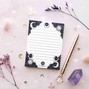 This photo shows an overhead view of the black and white version of this notepad with a pen for scale.