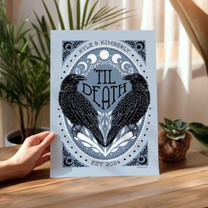 Unframed matte print that features 2 ravens in the shape of a heart & the words, “til death” in the center. Moon phases, botanical illustrations and hearts surround the ravens. The couple’s first names and anniversary date are arched on top and bot