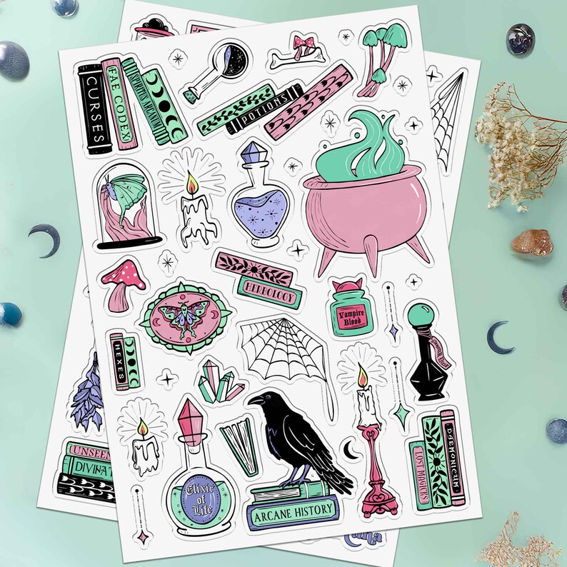 This photo showcases the second sheet of this two sheet set which has potions, candles, crystals, spellbooks, a moth in a cloche, mushrooms, sparkles, moth wall art, and a cauldron.