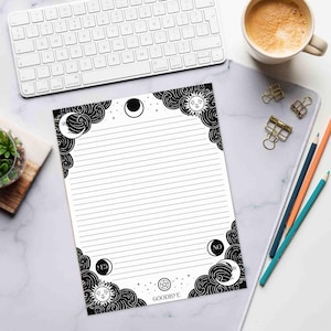This photo shows the 8.5 by 11 inch notepad on a desk with writing utensils for size comparison