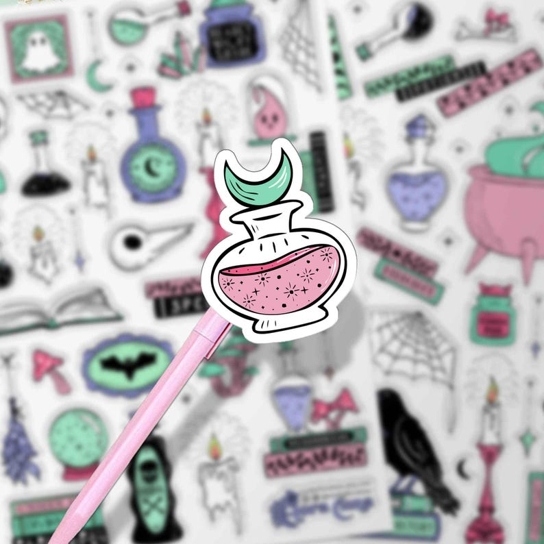 This is a close up shot of one of the potion stickers (a pink sparkly potion with a teal moon lid) on a pink pen.