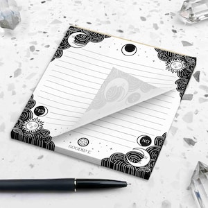 This photo shows the 5.5 by 6 inch spirit board notepad next to a pen