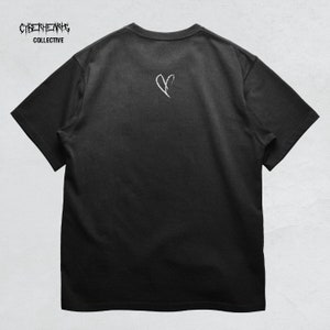 May include: Black t-shirt with a white broken heart graphic on the back. The text "CYBERHEARTS COLLECTIVE" is printed on the front of the shirt.