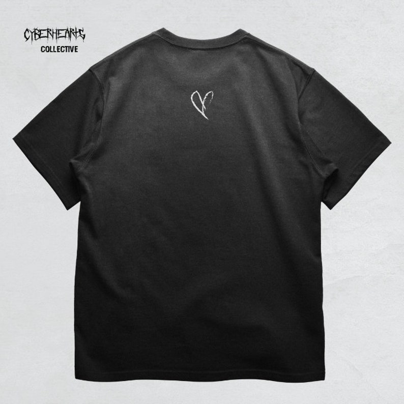 May include: Black t-shirt with a white broken heart graphic on the back. The text "CYBERHEARTS COLLECTIVE" is printed on the front of the shirt.