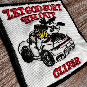 May include: Embroidered patch featuring the text "LET GOD SORT 'EM OUT" in red, above a cartoon car with a driver. The word "GLIPSE" is embroidered in red below the car. The patch has a white background with a black border.