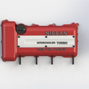 Può includere: Coperchio valvole motore rosso con accenti neri e scritta bianca che recita "NISSAN INTERCOOLER TURBO TWIN CAM 16VALVE".
