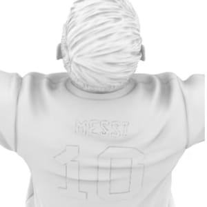 May include: White figurine of a person wearing a white jersey with the name "Messi" and the number "10" on the back.