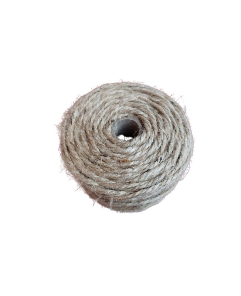 May include: A roll of natural twine, a type of string made from natural fibers, is wound around a cardboard core. The twine is a light brown color and has a rough texture.