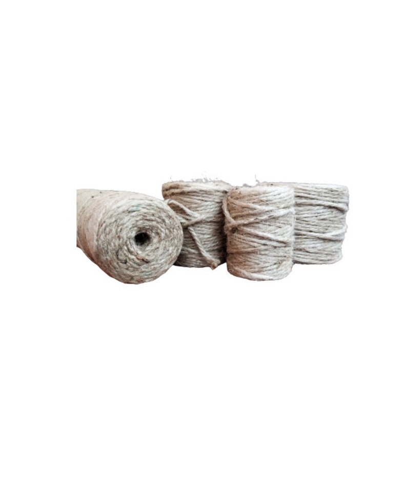 May include: Four spools of natural twine, each wound into a neat coil. The twine is a light beige color and appears to be made of natural fibers.
