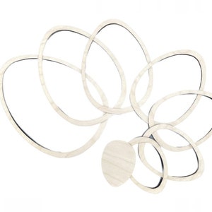 Könnte beinhalten: Eine weiße Holz-Wandskulptur mit einem wirbelnden Design aus überlappenden Kreisen.