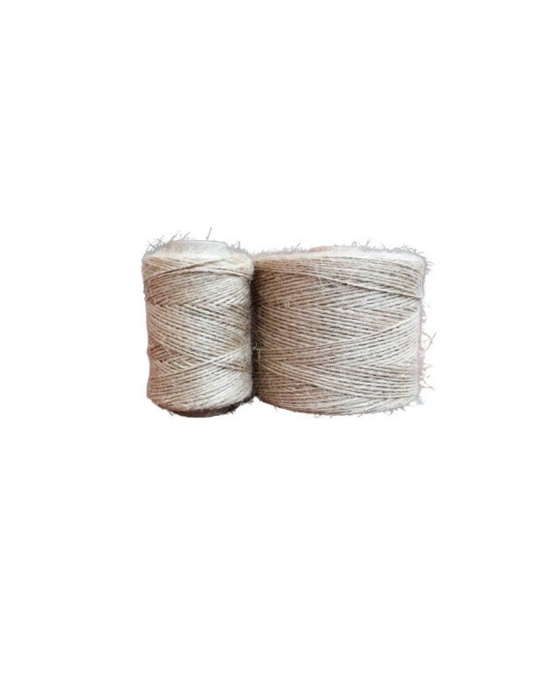 May include: Two spools of natural beige twine, wound tightly together.