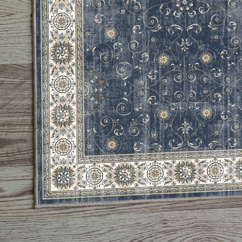 K&ouml;nnte beinhalten: Ein blauer und cremefarbener Teppich mit einem Blumenmuster. Der Teppich hat einen Rand mit einem sich wiederholenden Muster aus Kreisen und Blumen.