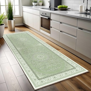 May include: A long rectangular runner rug featuring a soft sage green background with intricate white and dark green floral patterns and two prominent circular medallion designs centered along the length of the floor covering.