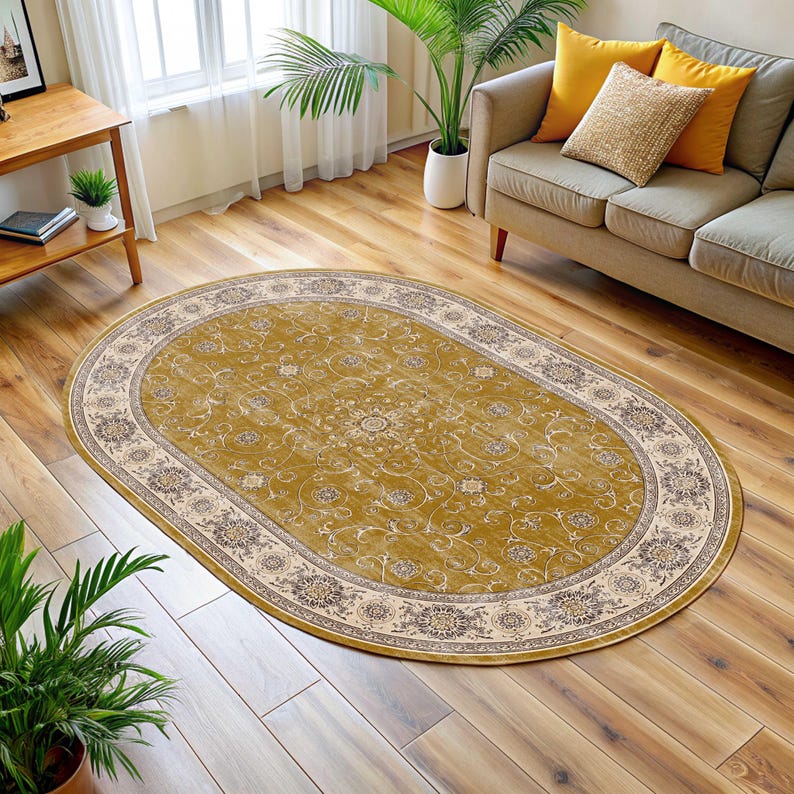 Pode incluir: Tapete oval amarelo mostarda com um padr&atilde;o floral detalhado. A borda &eacute; creme com um design floral repetido. O tapete est&aacute; colocado sobre um ch&atilde;o de madeira.