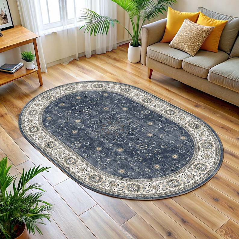 Pode incluir: Tapete oval com um centro azul escuro e uma borda creme. O tapete apresenta um padr&atilde;o floral no centro e na borda. Est&aacute; colocado sobre um piso de madeira em uma sala de estar.