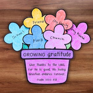 May include: A colorful paper craft depicting a flower pot with flower-shaped petals. The petals are labeled with words like "School," "Friends," and "My Family." The pot reads "GROWING gratitude" and includes a Bible verse.