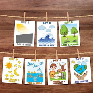 May include: Seven illustrated cards showing the days of creation, suspended by a string and pegs. Each card has colourful drawings and text, including "Day & Night", "Water & Sky", and "Land & Plants".
