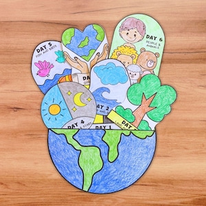 May include: A paper craft project featuring a large blue and green globe base with several layered cutouts depicting the seven days of creation. Each section includes hand-drawn illustrations and text labels such as Day 1, Day 2, Day 4, Day 5, and Day 6.