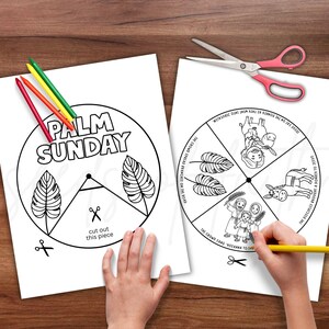 May include: Two white paper coloring pages with black outlines and text, featuring Palm Sunday themes. One page has the text "PALM SUNDAY" and leaf illustrations. The other depicts scenes from the story. Colored pencils and scissors are also visible.