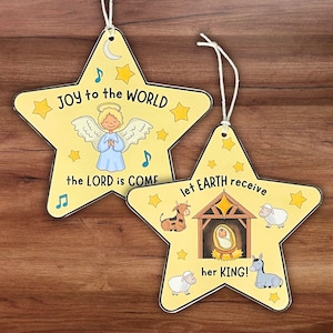 May include: Two star-shaped Christmas ornaments with white string. One features an angel and the text "JOY to the WORLD the LORD is COME." The other shows a nativity scene and the text "let EARTH receive her KING!"