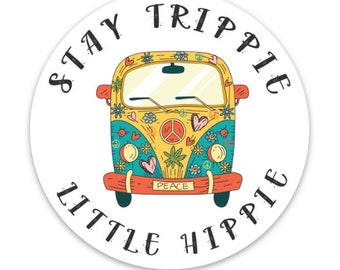 May include: A white circle with the text "Stay Trippy Little Hippie" around the edge. A yellow, blue, and red vintage van with peace signs and flowers is in the center. The van has a license plate that says "Peace."