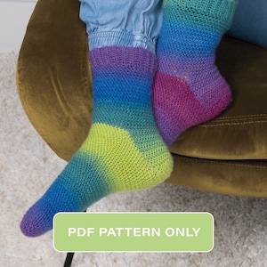 Könnte beinhalten: Ein Paar gestrickte Socken mit einem lebendigen Farbverlauf von Lila über Blau und Grün bis hin zu Gelb. Die Socken werden mit dem Text "PDF PATTERN ONLY" auf einem grünen Rechteck gezeigt.