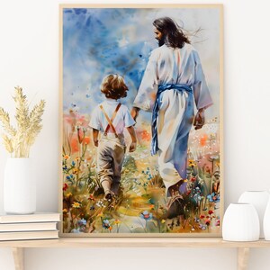 May include: Watercolor painting of a figure in white robes and a child walking through a field of wildflowers. The figure holds the child's hand, with a blue sky and soft colors in the background. The artwork is framed.