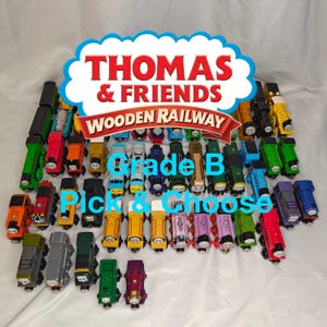 May include: A collection of colorful wooden Thomas & Friends train cars. The image features a variety of train engines in different colors, including red, green, yellow, and blue. The text "THOMAS & FRIENDS WOODEN RAILWAY" is displayed at the top.