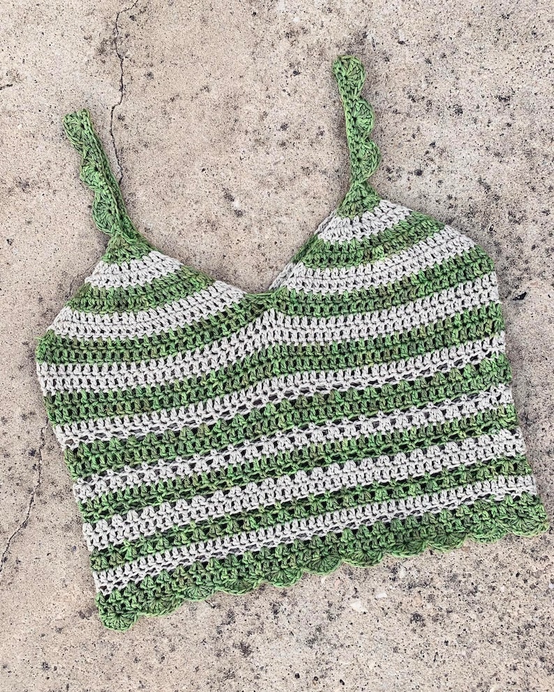 May include: Green and white striped crochet top with a scalloped edge. The top has thin straps and a cropped length.