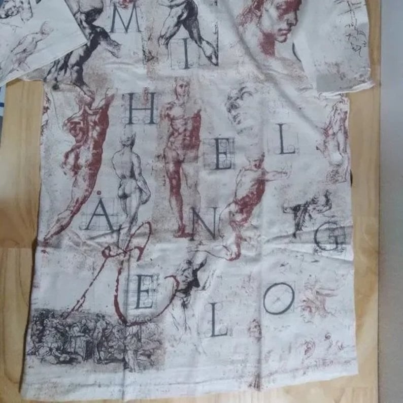 May include: A white t-shirt with a print of anatomical drawings and the word "Melencolia" in a stylized font.