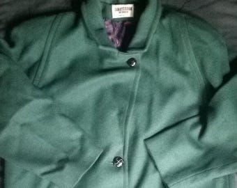 Puede incluir: Un abrigo verde oscuro con cuello con solapas y tres botones negros. El abrigo tiene mangas largas y una etiqueta que dice "DONNYSBROOK WOMAN". El forro interior es de tela morada estampada.