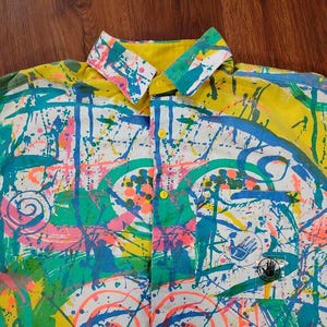 Puede incluir: Una taza de cer&aacute;mica blanca con un asa negra y el texto "But First, Coffee" en negrita negra. La taza est&aacute; llena de un l&iacute;quido oscuro, probablemente caf&eacute;, y se encuentra sobre una superficie clara.