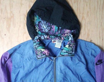 May include: A blue, purple, and black hooded jacket with a floral print lining and a Nike logo on the right sleeve.