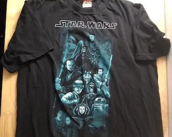 Peut inclure: T-shirt noir avec un imprimé graphique de personnages de Star Wars Episode I. Le graphique représente Dark Maul, Qui-Gon Jinn, Obi-Wan Kenobi et d'autres personnages du film.
