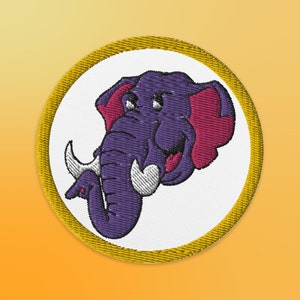 May include: A purple and pink cartoon elephant with a white tusk and a gold circle border.