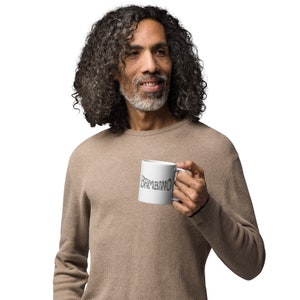 May include: A white ceramic mug with the word 'SYMBOLIC' written in black cursive lettering.